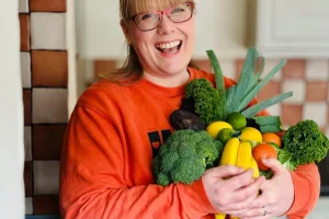 Claire Thomas Nutritonal Therapist Phlebotomist holding veg
